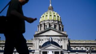 Man walks in front of Pennsylvania state capitol