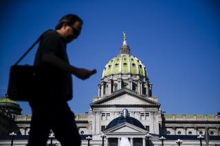 Man walks in front of Pennsylvania state capitol